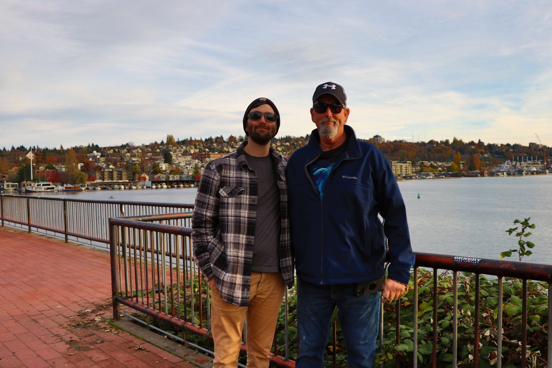 Bob Guiffre and his son, Bobby, standing together at a waterfront railing on an autumn day